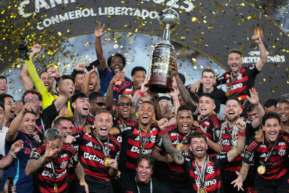 Jogadores do Flamengo comemoram com o troféu após derrotar o Palmeiras na final da Copa Libertadores, realizada em Lima, Peru, no sábado, 29 de novembro de 2025. — Foto: AP Photo/Martin Mejia