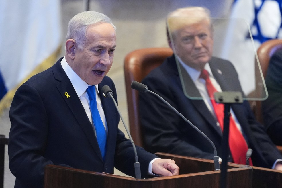 O primeiro-ministro de Israel, Benjamin Netanyahu, discursa no Parlamento de Israel ao lado do presidente dos EUA, Donald Trump, em 13 de outubro de 2025. — Foto: Evan Vucci/ Pool via Reuters