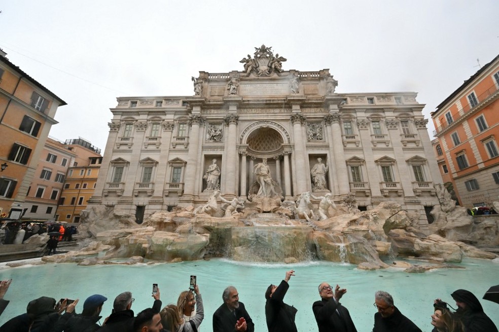 Autoridades italianas jogam moedas na Fontana di Trevi na reabertura do local — Foto: Alberto PIZZOLI / AFP
