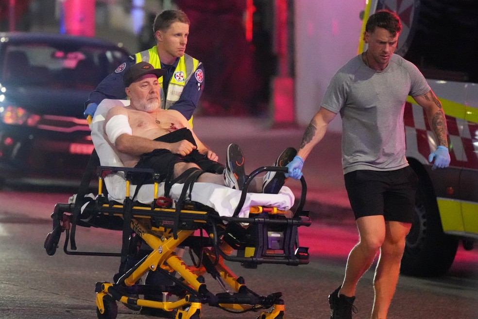 Ferido é levado após tiroteio em Bondi Beach, na Austrália — Foto: AP Photo/Mark Baker