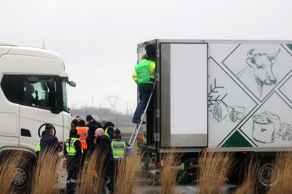 Agricultores inspecionam caminhão com alimentos importados em uma rodovia no norte da França em protesto contra o acordo entre União Europeia e Mercosul — Foto: FRANCOIS LO PRESTI / AFP