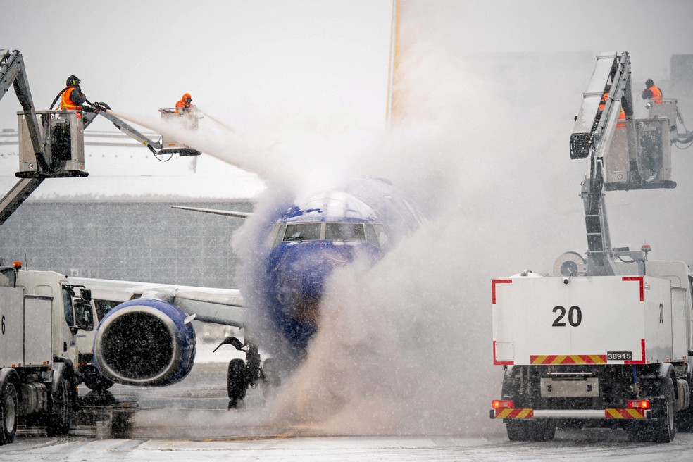 Uma equipe de degelo trabalha durante a tempestade de inverno Fern em uma aeronave da Southwest Airlines no Aeroporto Internacional de Nashville, nos EUA — Foto: Andrew Nelles/USA Today Network via REUTERS