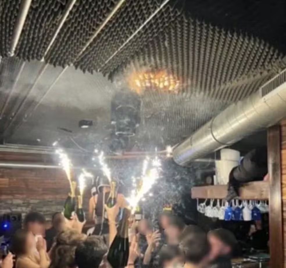 Imagem mostra teto de bar em estação de esqui da Suíça que pegou fogo já em chamas enquanto frequentadores levantam bebidas com sinalizadores, em 1º de janeiro de 2026 — Foto: Reprodução/ Redes Sociais