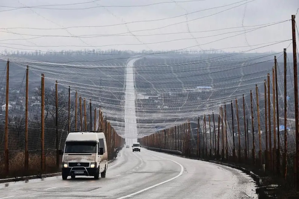 Na Ucrânia, redes antidrones se estendem por quilômetros, suspensas em postes de madeira — Foto: Getty Images via BBC