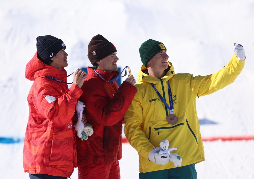 Competidores fazem 'selfie' em pódio nos Jogos Olímpicos de Inverno, na Itália, em fevereiro de 2026. — Foto: Hannah McKay/ Reuters
