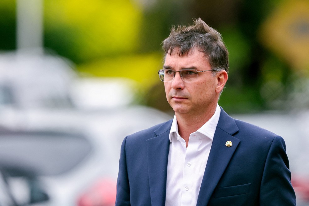 O senador Flávio Bolsonaro, filho do ex-presidente Jair Bolsonaro, caminha após visitar seu pai no prédio da Polícia Federal, onde o ex-presidente está sob custódia após violar as regras da tornozeleira eletrônica enquanto cumpria prisão domiciliar, em Brasília, Brasil, em 25 de novembro. — Foto: Jorge Silva/Reuters
