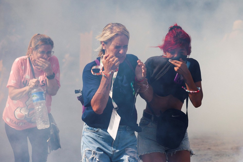 Mulheres correm em meio a gás lacrimogêneo durante um protesto em frente ao Senado argentino, em 11 de fevereiro de 2026 — Foto: REUTERS/Cristina Sille