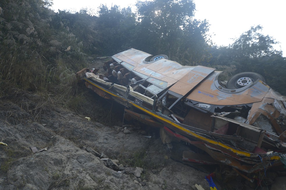 Destroços de um ônibus são vistos na margem do rio Trishuli — Foto: Foto AP/Bijay Rai