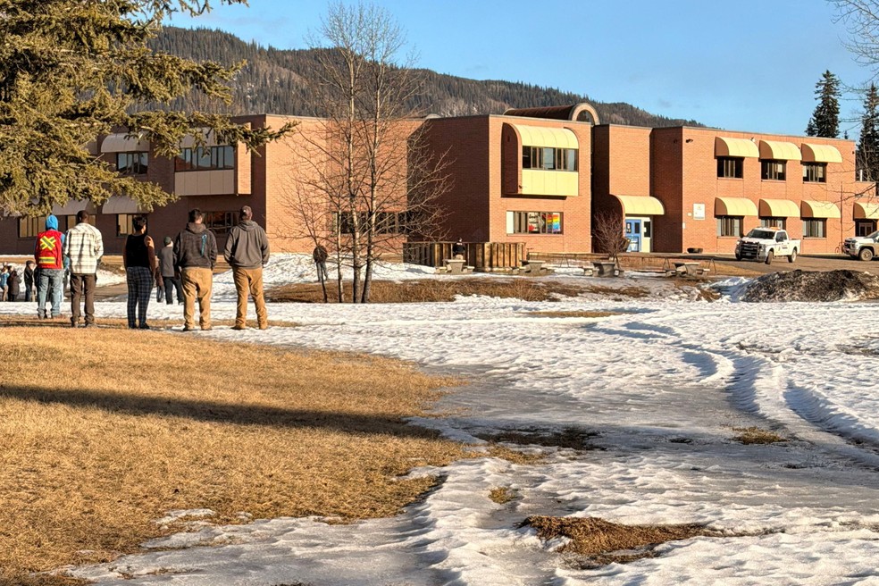 Pessoas se reúnem do lado de fora do prédio de escola na cidade de Tumbler Ridge, Colúmbia Britânica, Canadá, após ação de atiradora em 10 de fevereiro de 2026. — Foto: Western Standard/ Jordon Kosik/Handout via REUTERS