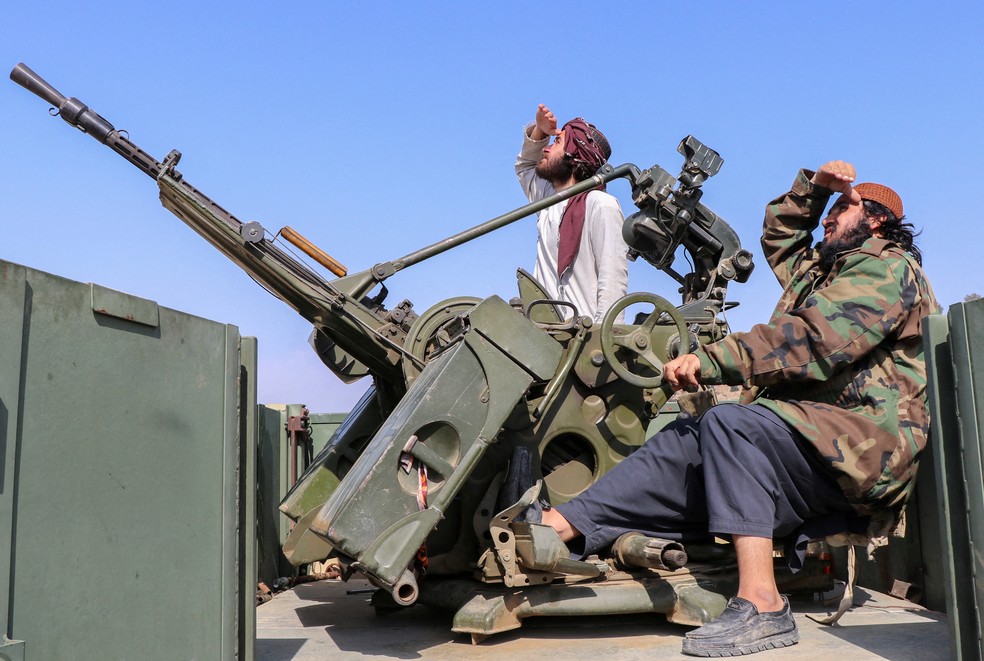 Soldados talibãs sentam-se ao lado de uma arma antiaérea enquanto vigiam os caças paquistaneses, na província de Khost, Afeganistão, em 27 de fevereiro de 2026 — Foto: Reuters
