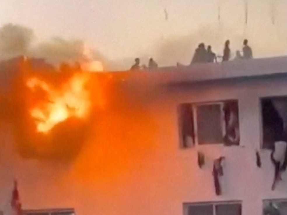 Pessoas protestam no topo de um prédio em chamas contra o não pagamento de auxílio financeiro na Universidade Cheikh Anta Diop, em Dakar, Senegal, em 9 de fevereiro de 2026 — Foto: Reuters