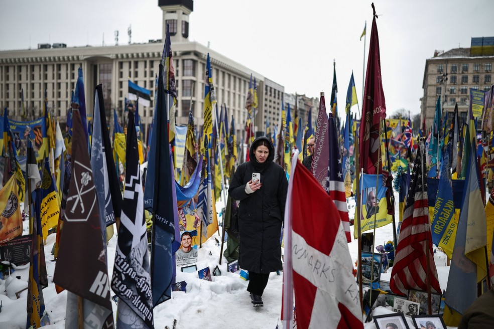 Pessoa caminha por um memorial improvisado em homenagem a soldados ucranianos e estrangeiros mortos na Praça da Independência, em Kiev, em 23 de fevereiro de 2026. — Foto: Henry Nicholls/AFP