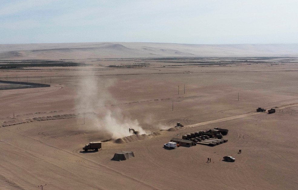 Vista aérea de maquinário pesado operando próximo ao posto fronteiriço de Chacalluta, na fronteira entre Chile e Peru, em 16 de março de 2026 — Foto: PATRICIO BANDA / AFP