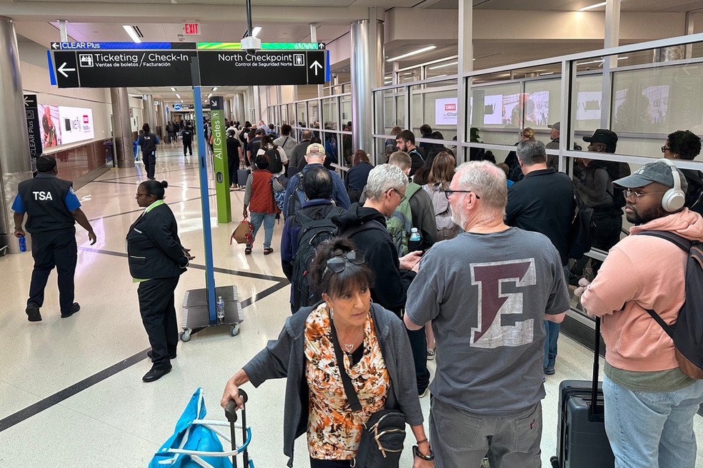 Passageiros fazem fila para a checagem de passaportes no aeroporto internacional de Atlanta, nos EUA, em 21 de março de 2026. — Foto: Jeff Amy/ AP