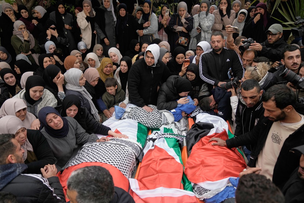 Palestinos velam corpos durante funeral família morta por soldados israelenses na Cisjordânia. — Foto: AP Photo/Majdi Mohammed