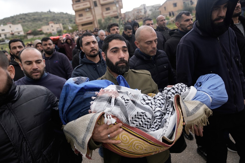 Palestino carrega corpo de Muhammad Bani Odeh, de 5 anos, durante funeral de família morta durante operação do Exército israelense na Cisjordânia. — Foto: AP Photo/Majdi Mohammed