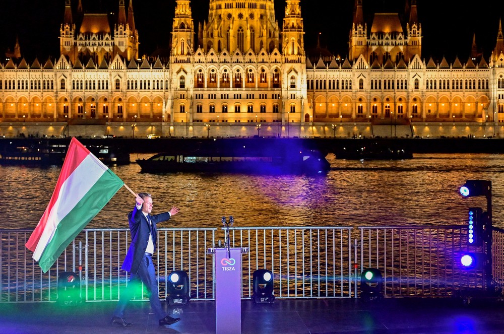 Peter Magyar, líder do partido de oposição Tisza, segura uma bandeira nacional após os resultados parciais da eleição parlamentar, em Budapeste, Hungria, em 12 de abril de 2026. — Foto: REUTERS/Marton Monus