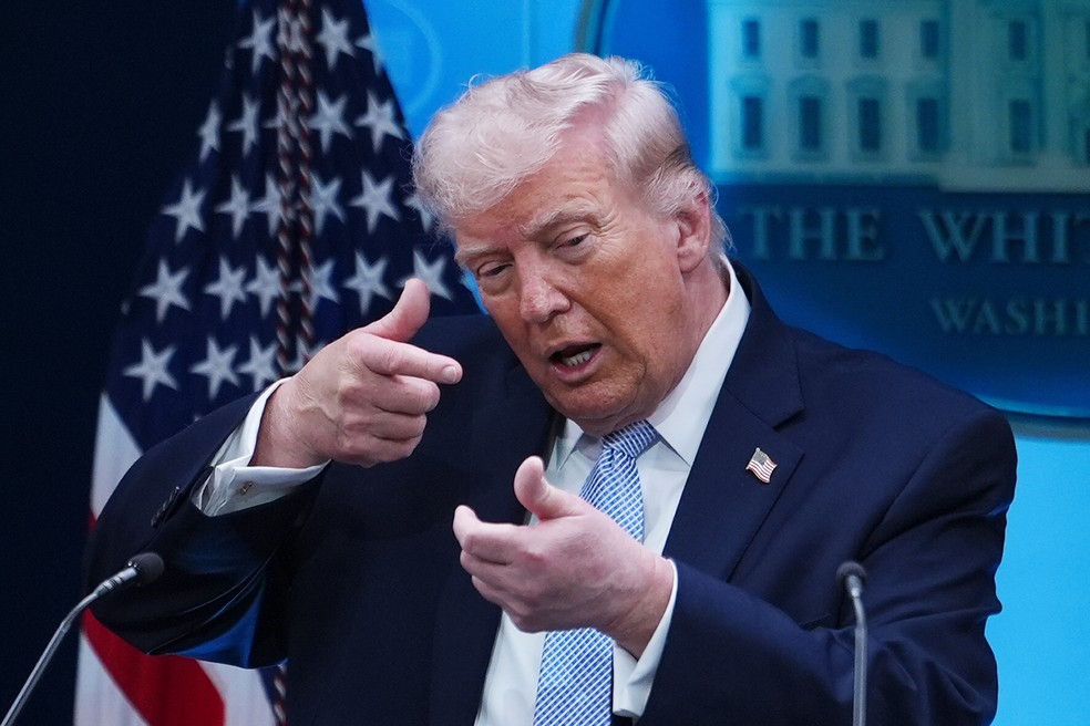 Trump finge mirar arma de precisão enquanto fala com repórteres na Sala de Imprensa na Casa Branca, em 6 de abril de 2026 — Foto: AP Photo/Julia Demaree Nikhinson