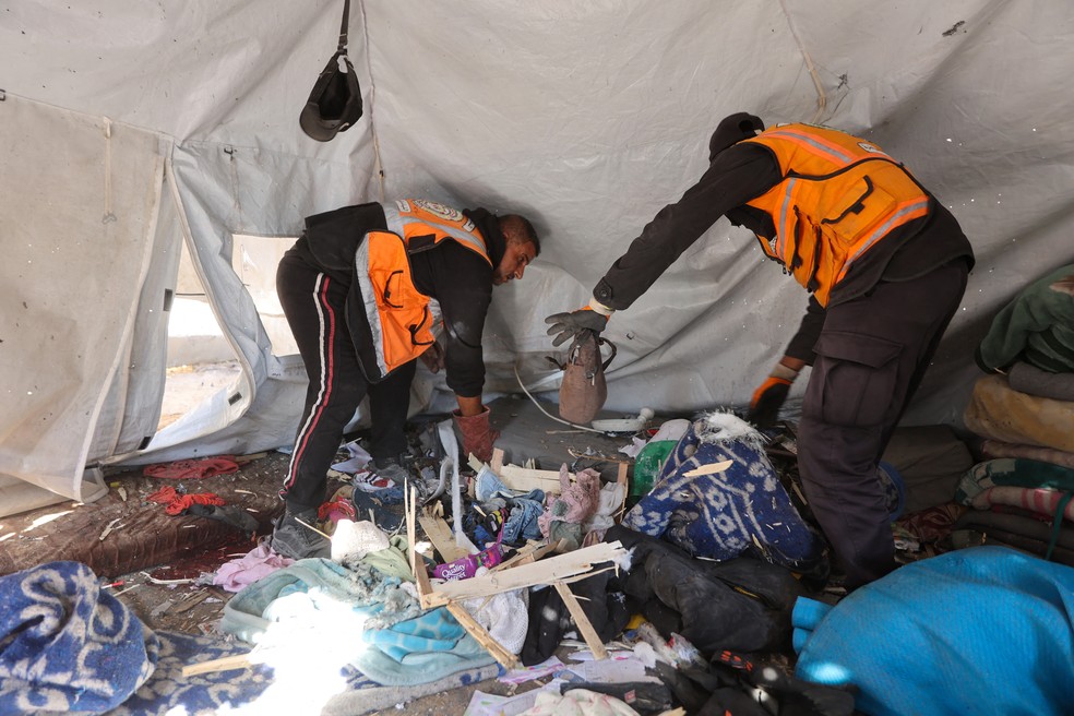 Socorristas inspecionam o interior de uma tenda que abrigava pessoas deslocadas após um ataque no bairro de al-Rimal, na Cidade de Gaza, em 6 de junho de 2026 — Foto: OMAR AL-QATTAA / AFP