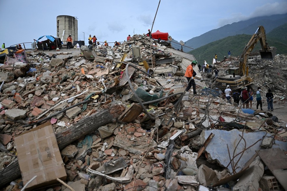 Trabalhadores removem escombros de prédios desabados em Caraballeda, estado de La Guaira, Venezuela, em 9 de julho de 2026, após os terremotos de 24 de junho. — Foto: RAUL ARBOLEDA / AFP