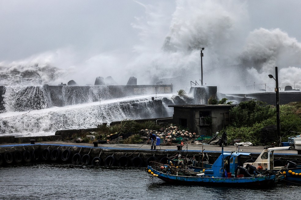 Barco de pescadores próximo a ondas violentas batendo contra barreira marítima na costa de Yilan, em Taiwan, enquanto tufão Bavi se move em direção à ilha em 10 de julho de 2026. — Foto: I-Hwa Cheng/AFP
